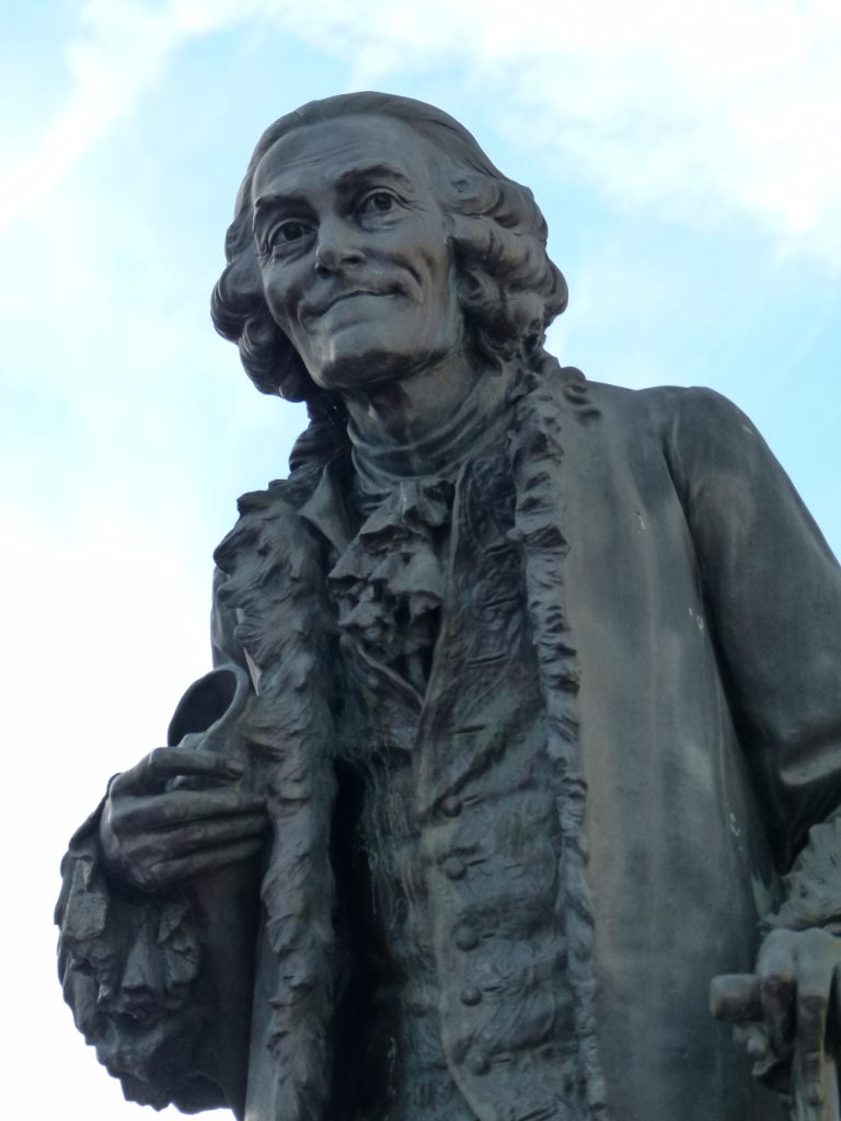 Statue of Voltaire at Ferney, 1890, sculptor Émile-Placide Lambert (1828–1897). Photo: Brücke-Osteuropa, own work, CC0, via Wikimedia Commons (https://commons.wikimedia.org/w/index.php?curid=22669379)